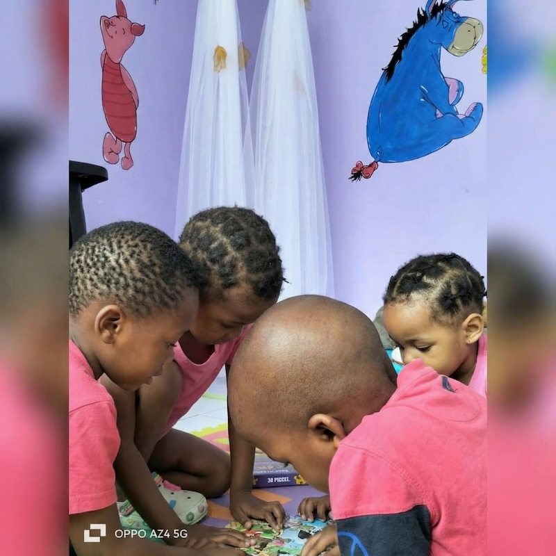 Children working together on puzzle play